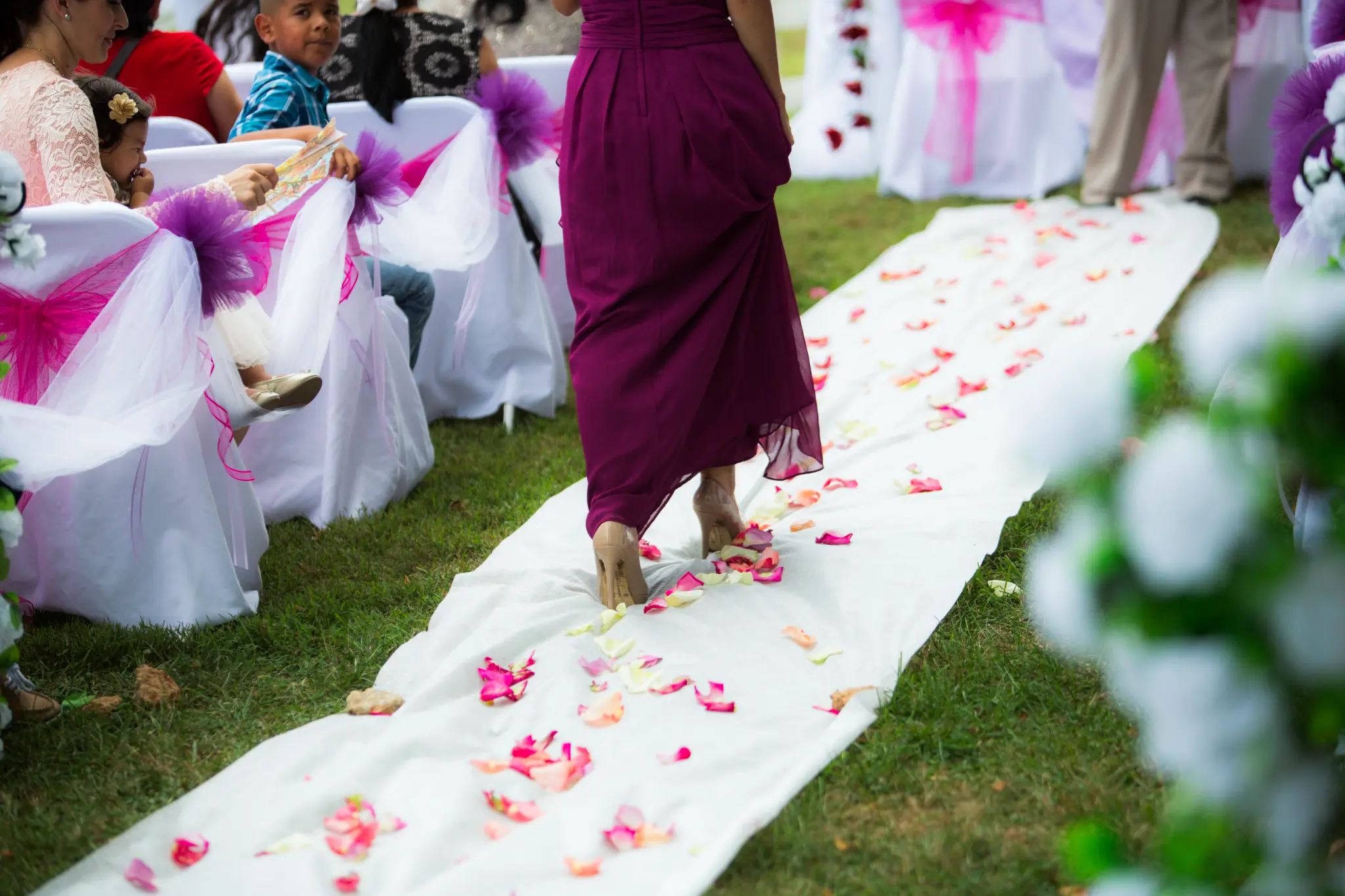 Bridesmaid walking the rose-petal aisle
